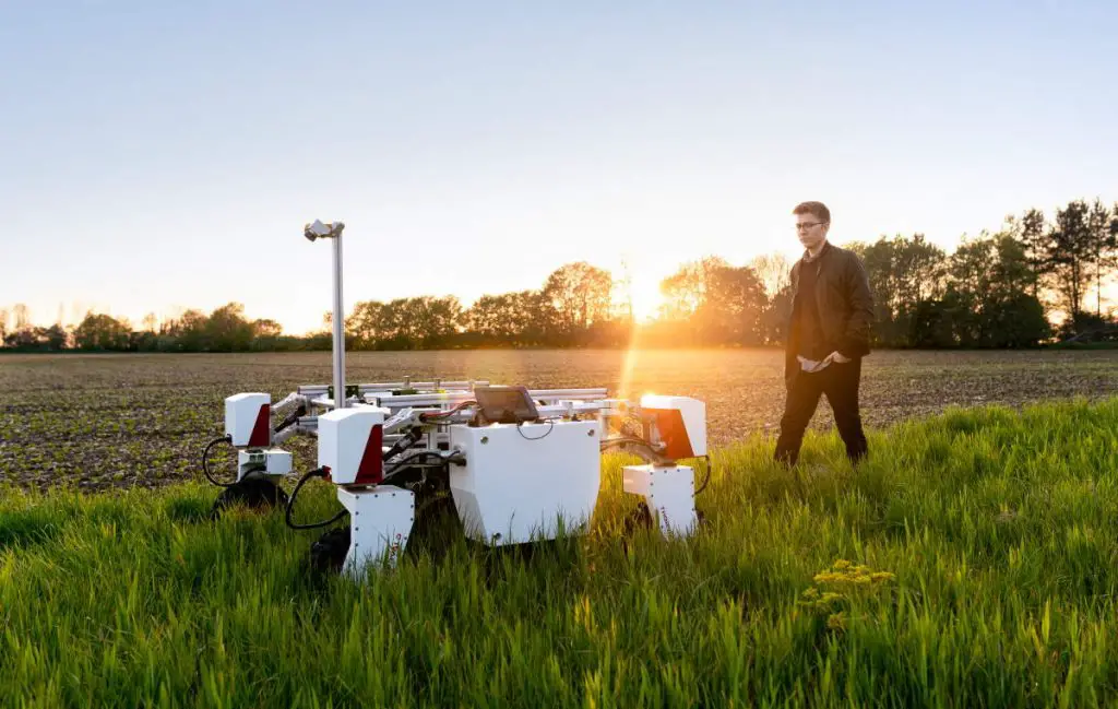 A mechanical engineer with sustainable agricultural robot in field